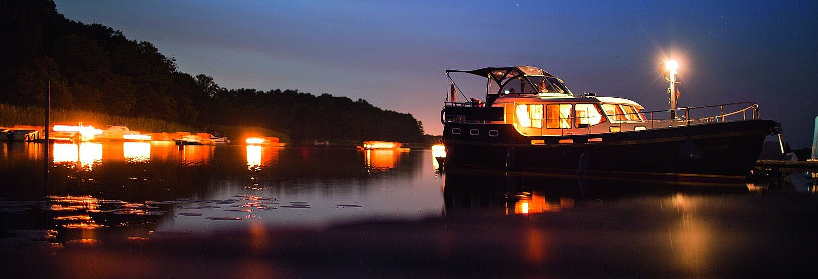 eine unserer Yachten bei Abenddämmerung auf dem Wasser 