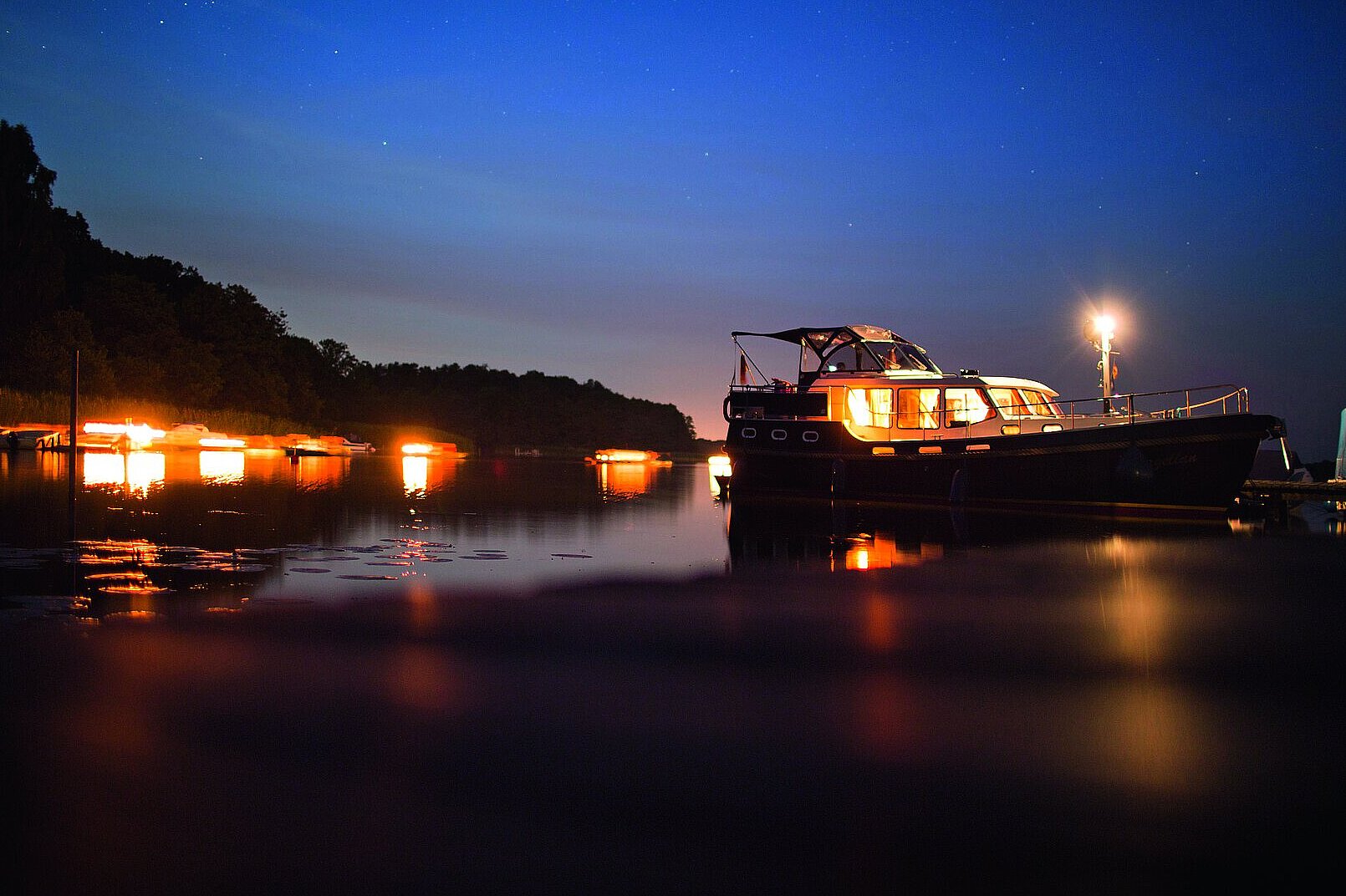 eine unserer Yachten bei Abenddämmerung auf dem Wasser 