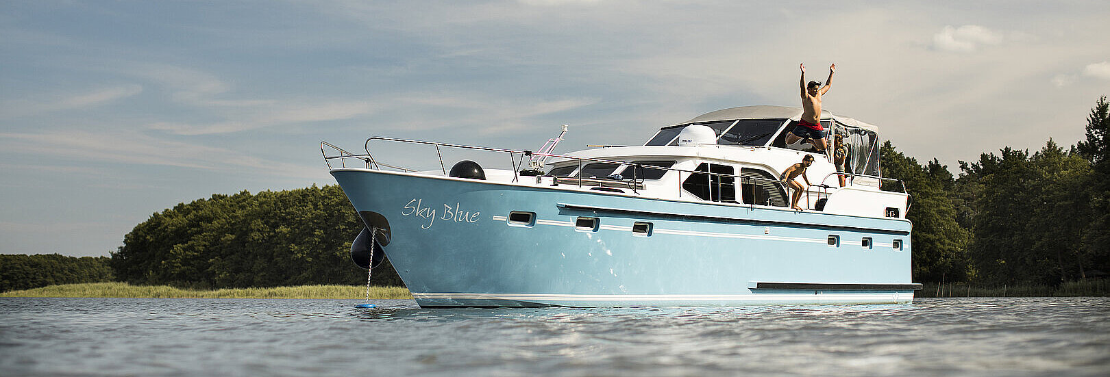 Personen springen von einer Yacht aus ins Wasser